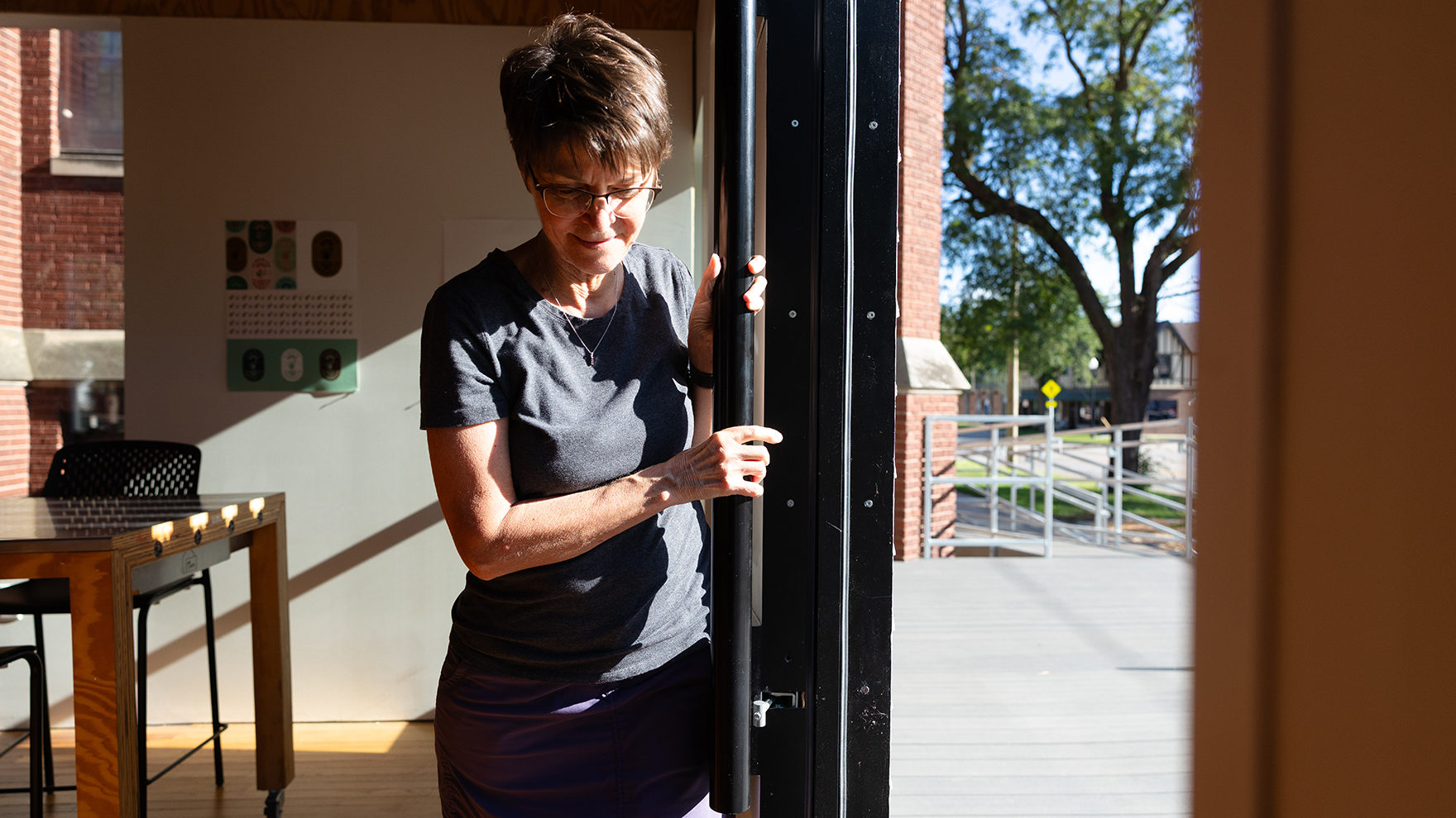 Jean Stryker opens the large sliding door at the front of the Art Chapel closed. Designed by Nebraska architecture students, the door contains a smaller, Craftsman-style door that can be used in cold or inclement weather. It is designed to open the Art Chapel up and draw members of the public into the space.