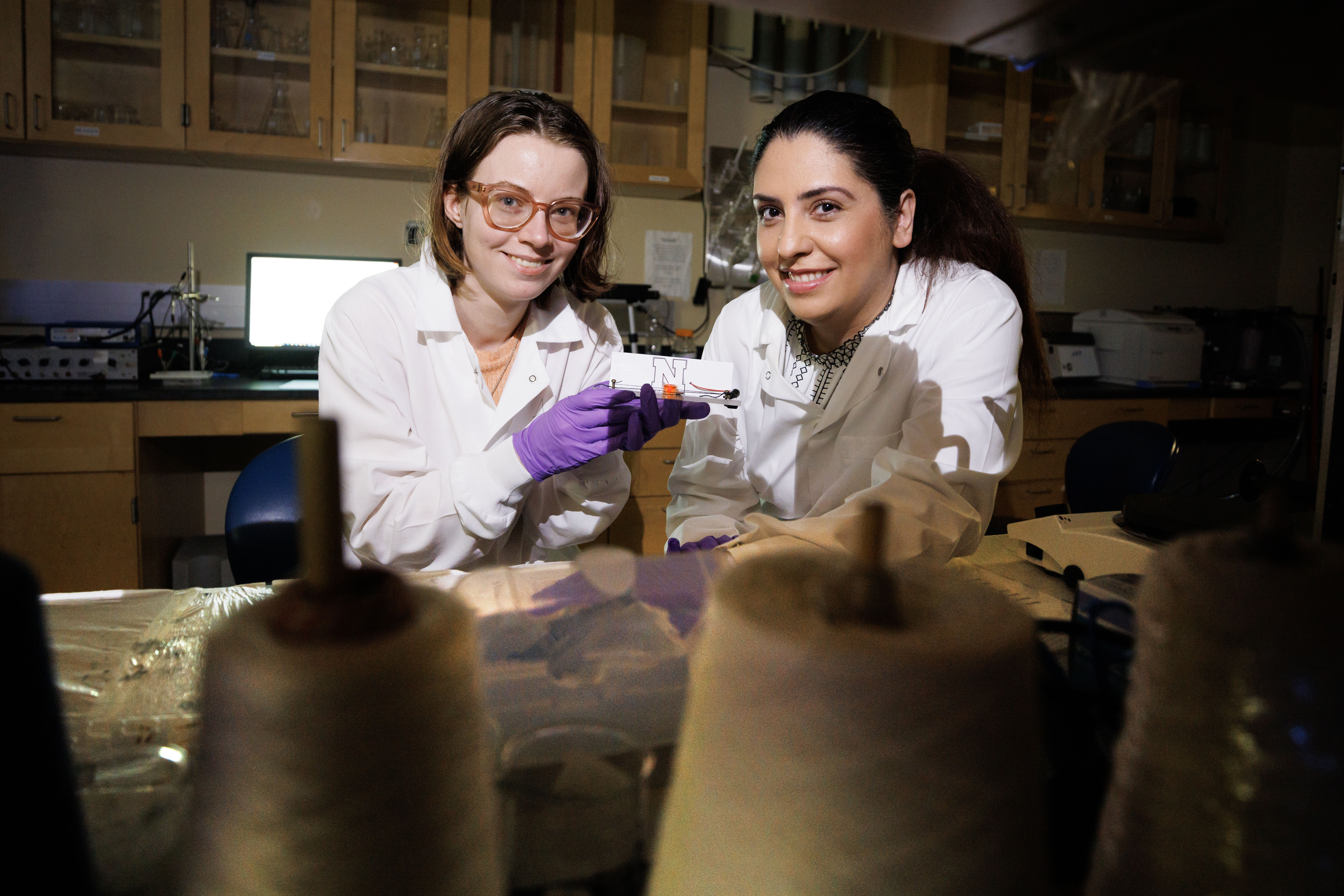 Alyssa Grube (left), a graduate student in chemical and biomolecular engineering, and Mona Bavarian, assistant professor of chemical and biomolecular engineering, hold a textile-based supercapacitor.