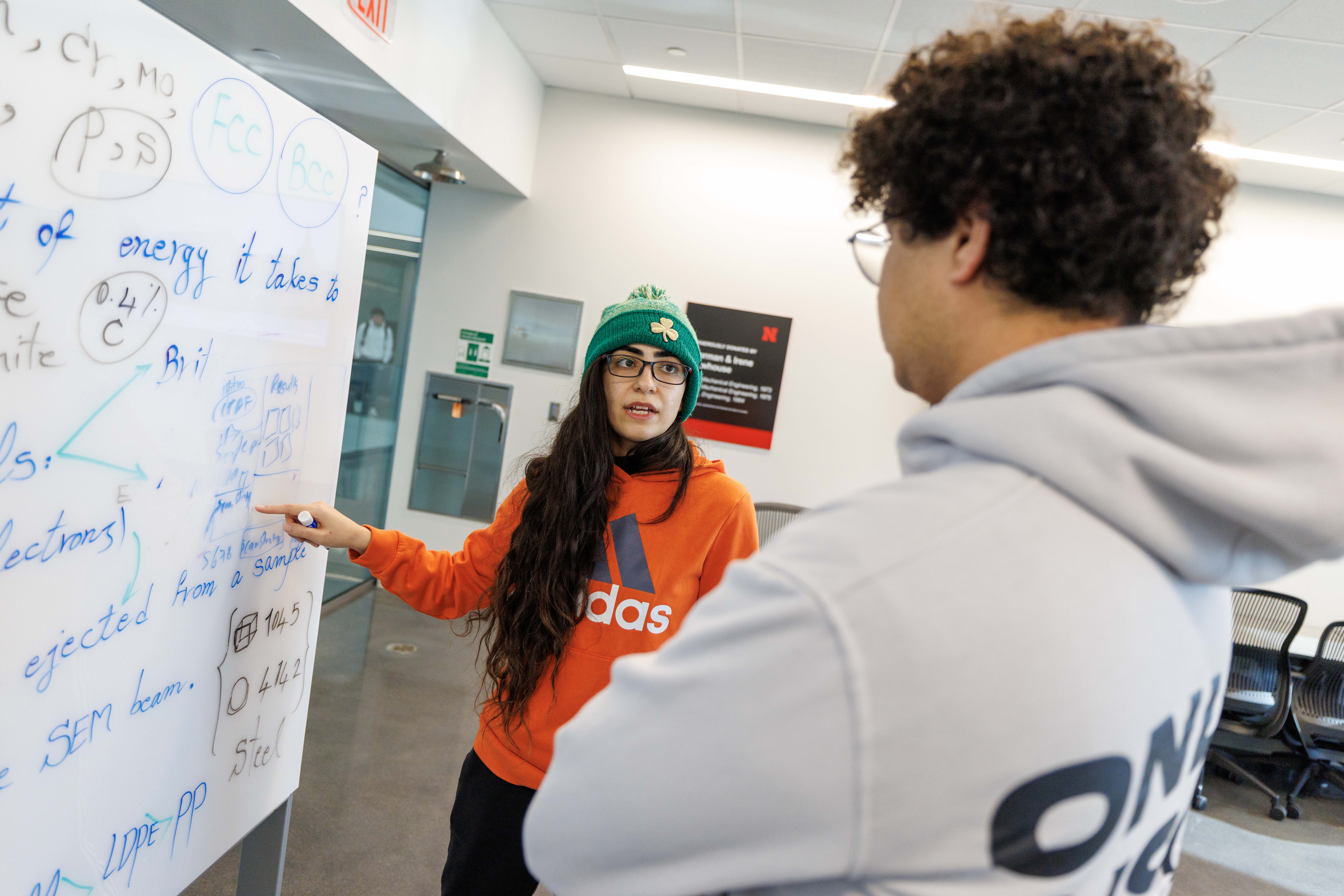 Graduate student Sahar Beigzadeh (left) shows freshman Ahmed Salem how to record findings from microhardness testing inside Kiewit Hall in December 2024.