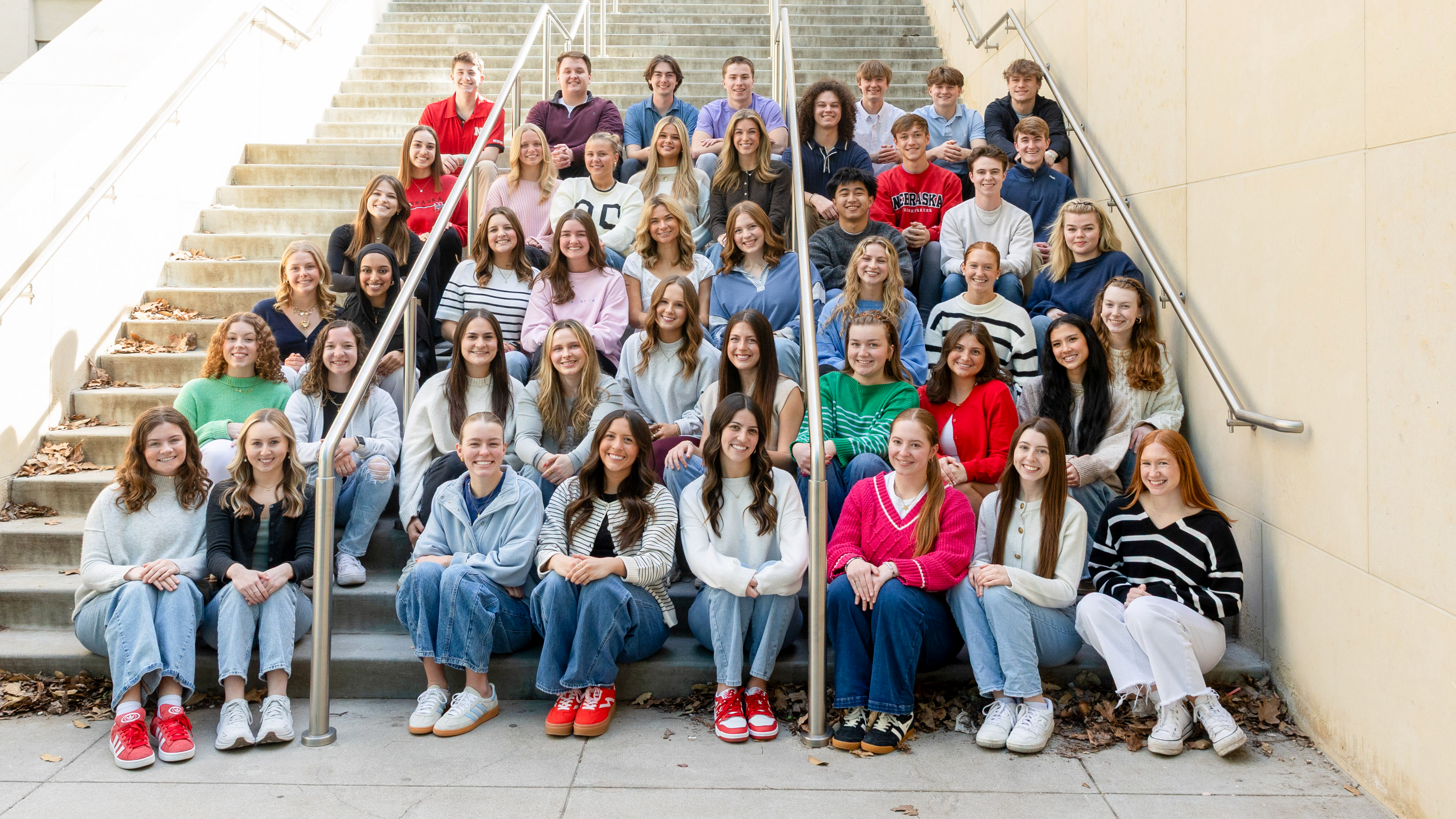 Forty-five students — all new strengths coaches in the University of Nebraska–Lincoln's Clifton Strengths Institute — sit on an outdoor staircase.