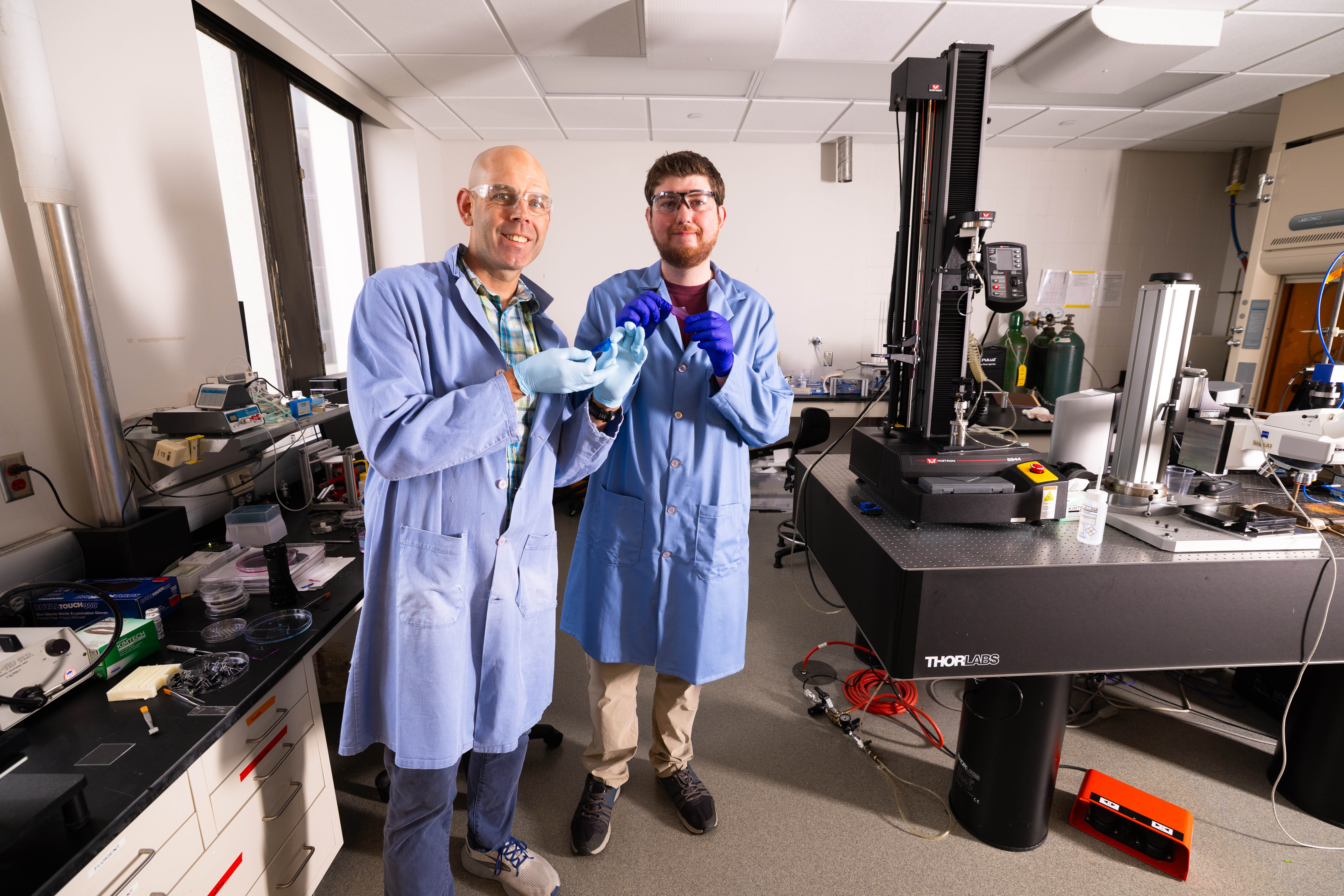 Stephen Morin, associate professor of chemistry, and Brennan Watts, a fourth-year doctoral student in chemistry, hold two colorful hydrogel skins that can act similarly to the color-changing skin of cephalopods such as octopi and cuttlefish.