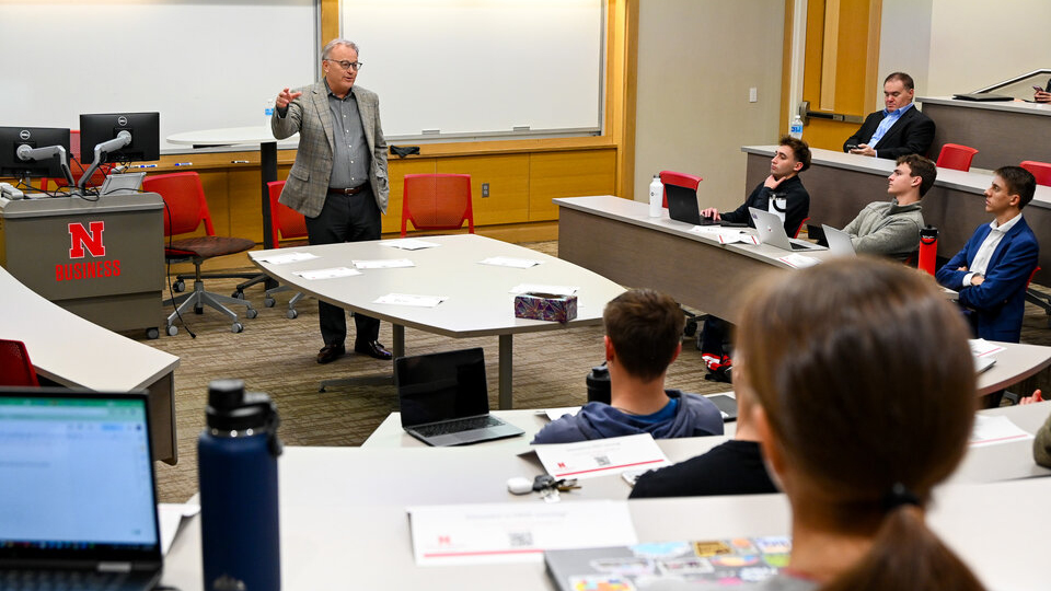 Brad Knuth, senior vice president of D.A. Davidson Nebraska and a Husker alumnus, speaks to students in front of a classroom.