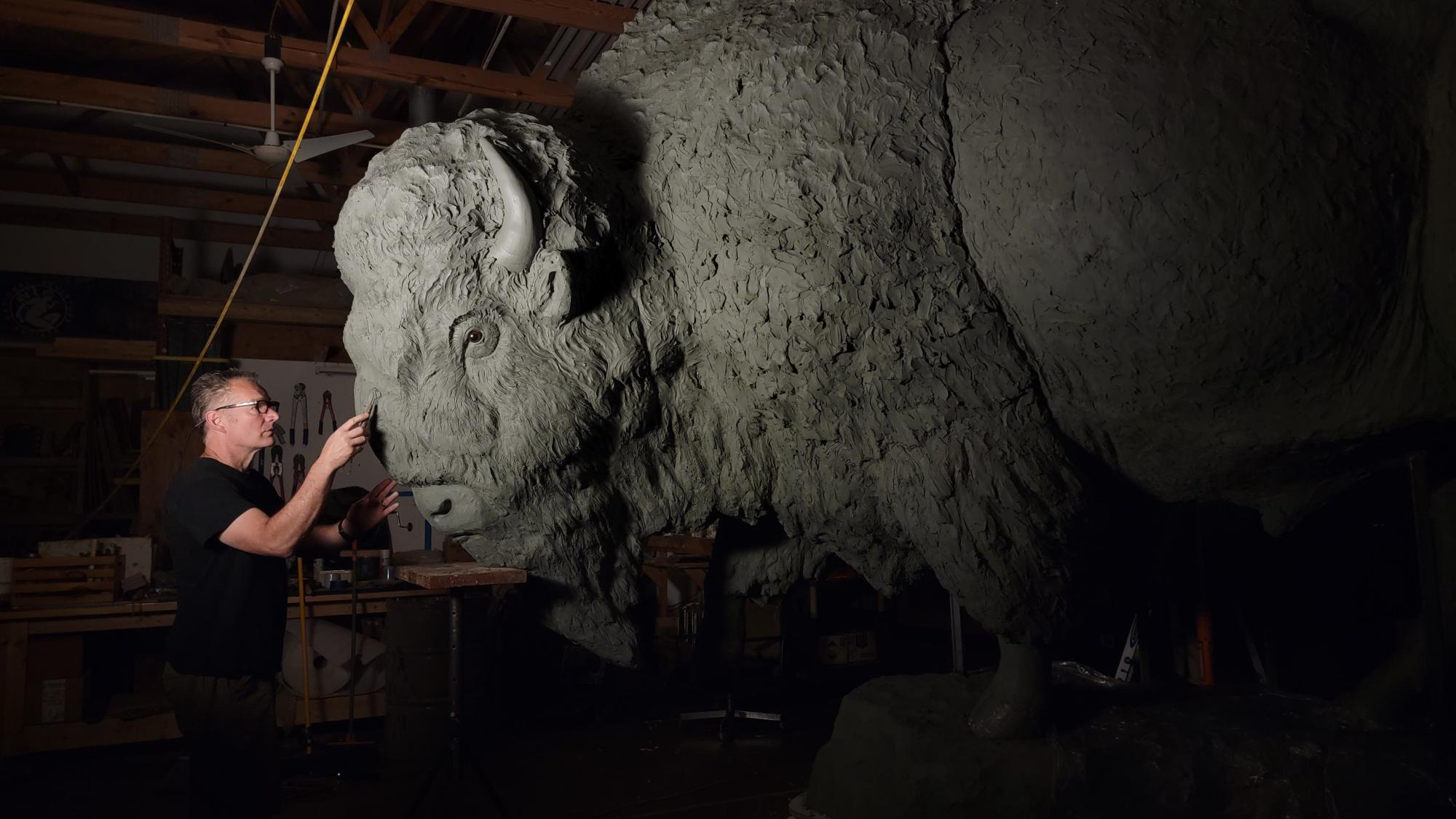 Nebraska artist Gary Staab carves the face of a giant bison statue.