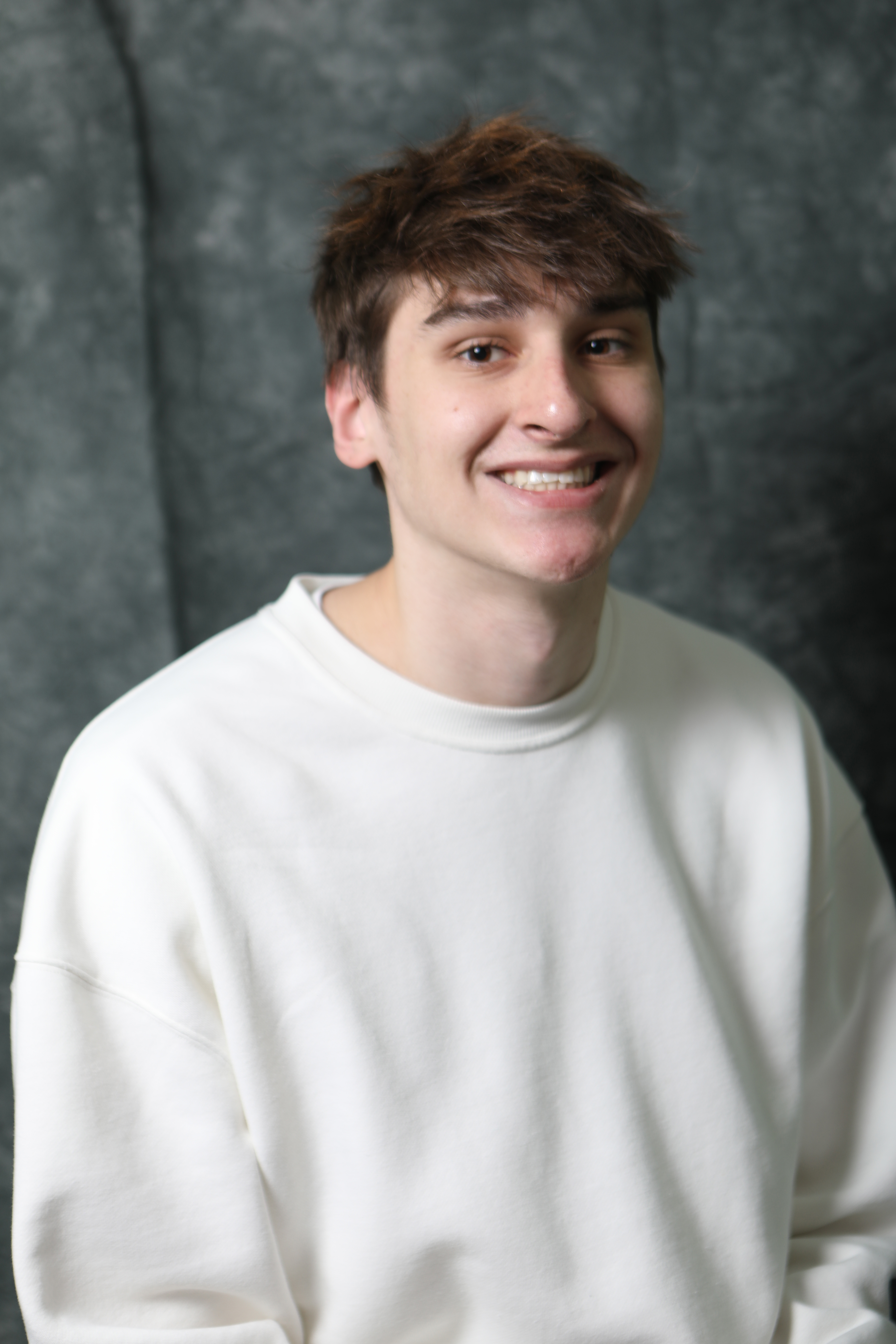 Color portrait of Ben Beecham, senior advertising and public relations, broadcasting, and sports media and communication major at the University of Nebraska–Lincoln. He is wearing a white sweatshirt.