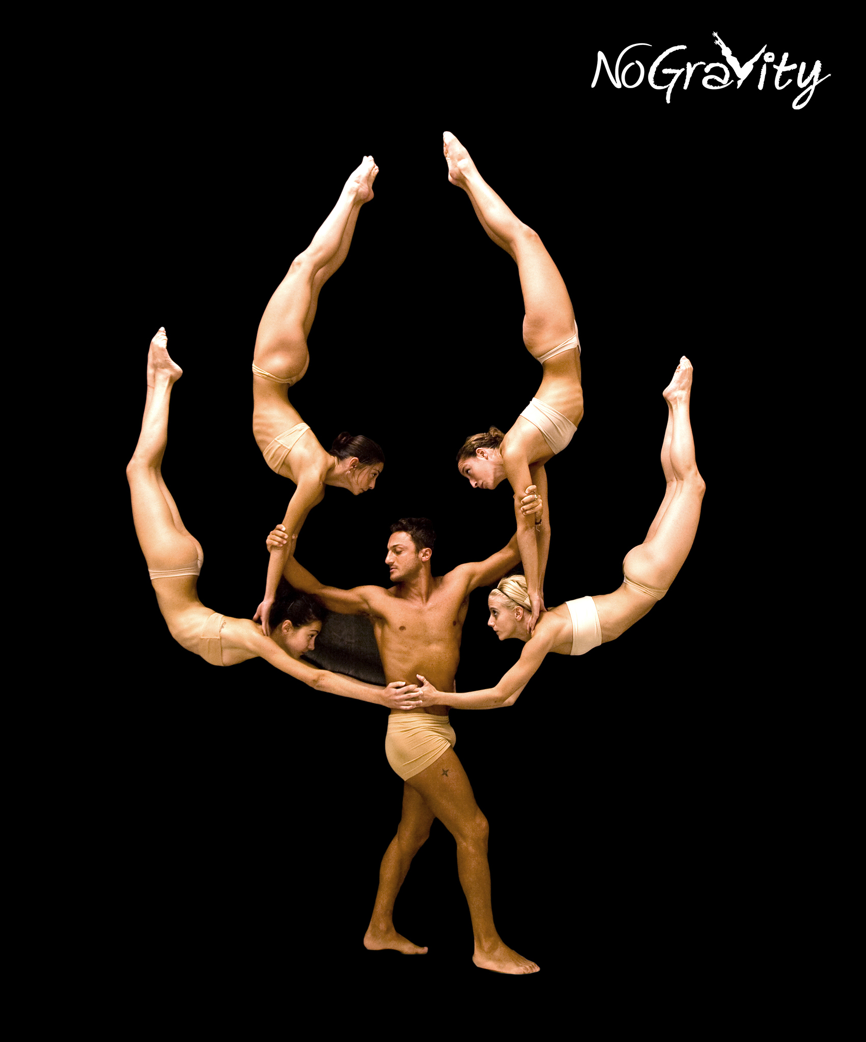 A bare-chested man holds up four scantily clad women in an acrobatic pose against a black background.