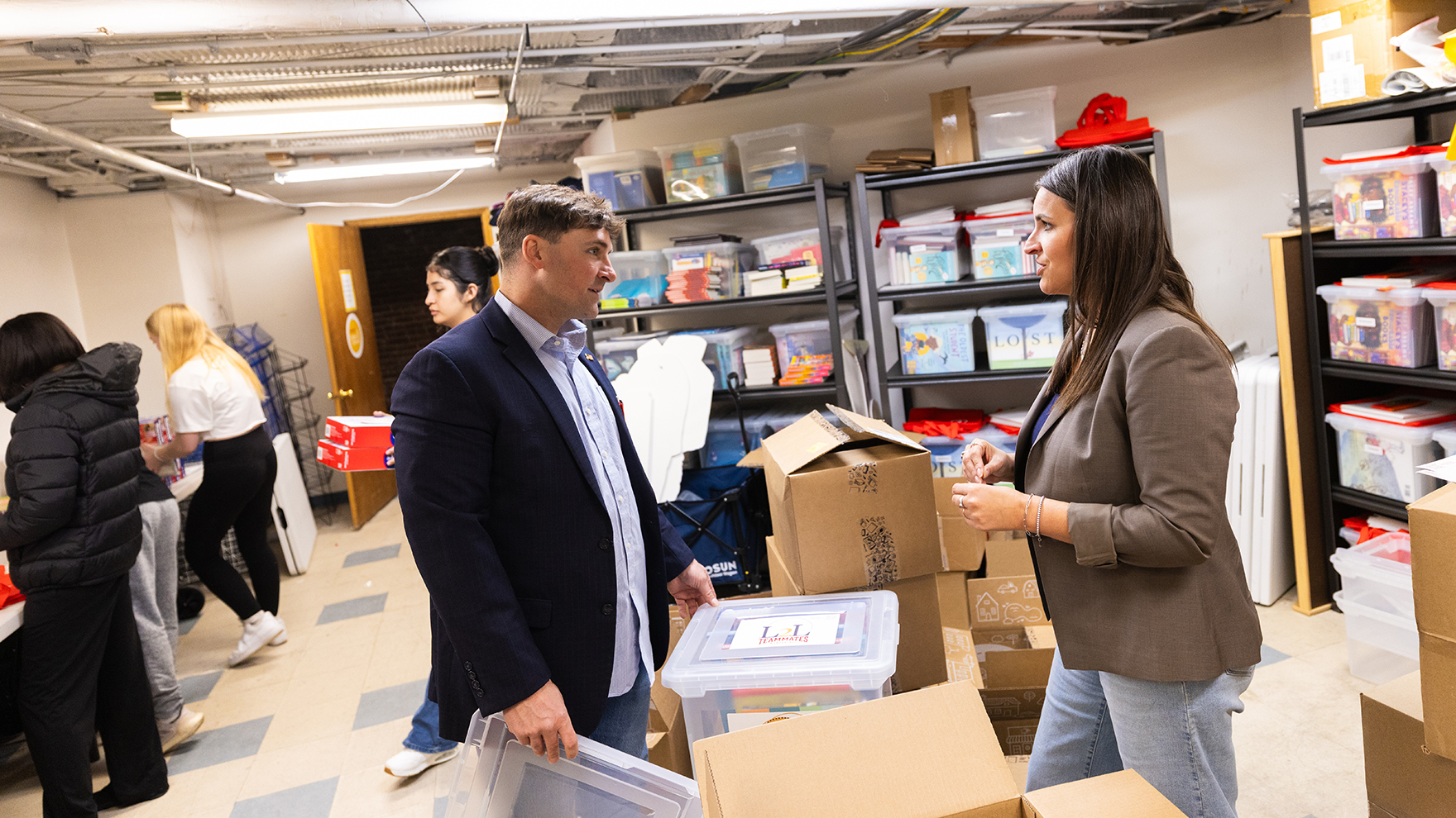 Kathleen Ousey, executive director of Linked2Literacy, talks with graduate student Ben Bentzinger about the nonprofit's programs, which provide diverse books at no cost to children and families. Linked2Literacy is based in Lincoln, but works with organizations across Nebraska to increase access to books.