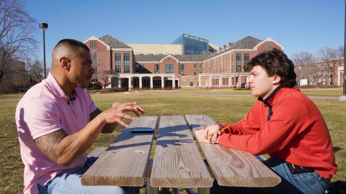 A young man interviews a formerly incarcerated man at a table on the University of Nebraska–Lincoln's Meier Commons.