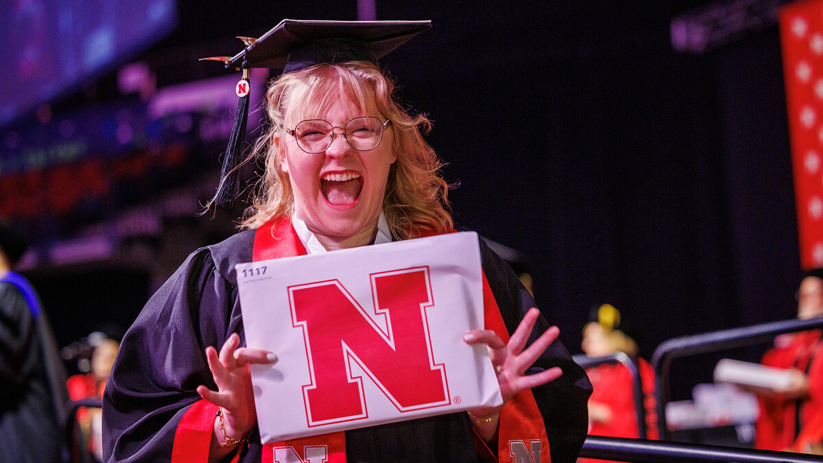 Abi Trembly, an emerging media arts major, shows off her diploma after receiving it on stage during the morning undergraduate commencement ceremony in Pinnacle Bank Arena on May 17.