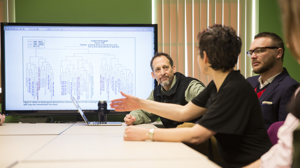 Matthew Jockers (left) discusses with students at the Nebraska Literary Lab their digital projects examining the language of Willa Cather.