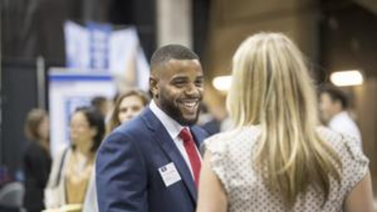 Student talks with employer at Business & Liberal Arts Career Fair.