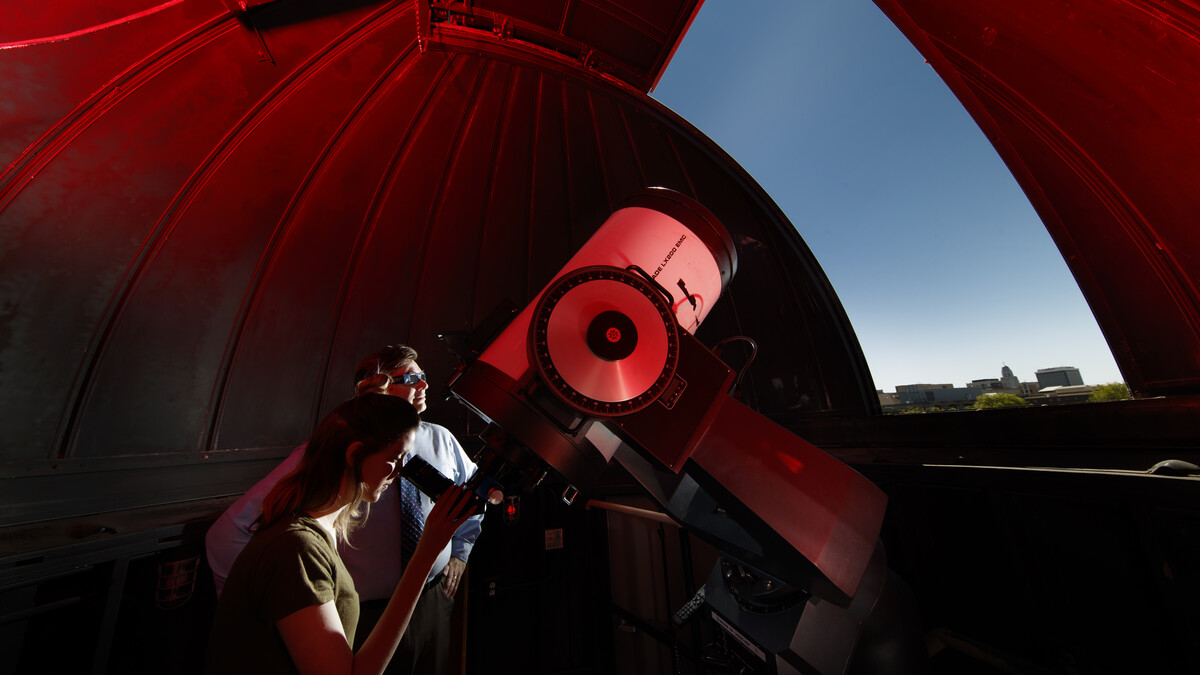 Michael Sibbernsen (right) and Hannah Paxton use the observatory atop the Stadium Parking Garage at the University of Nebraska–Lincoln. The university will use the observatory to record the Aug. 21 total solar eclipse.