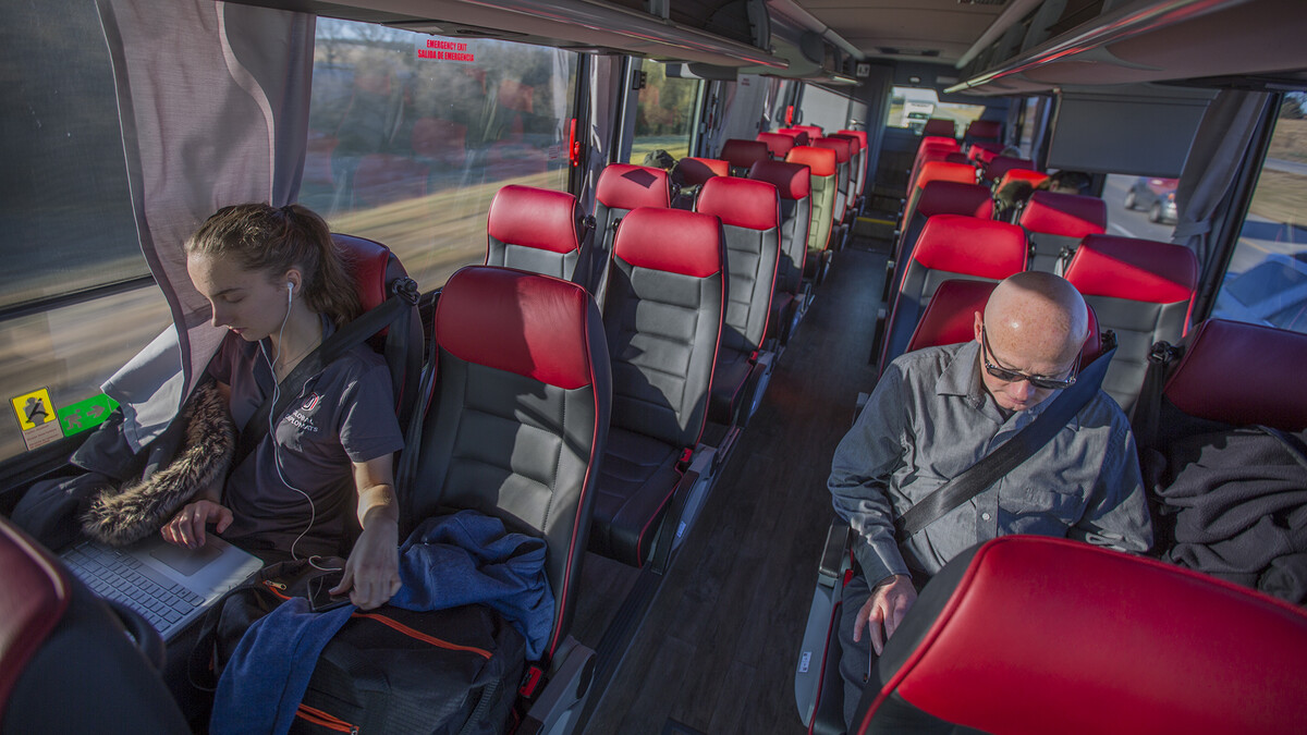 Natalija Ward (left) and Tim Terrell work on computers as the N-E Ride shuttle glides down Interstate 80 near Mahoney State Park. The shuttle runs 8 a.m. to 6 p.m. weekdays.