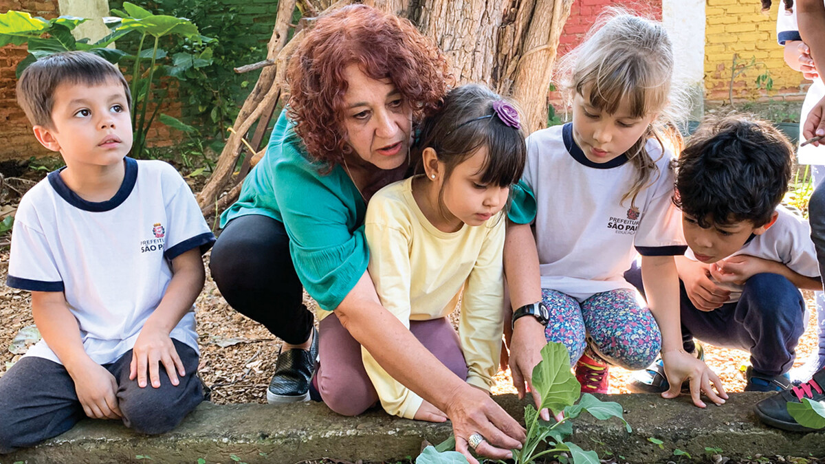 Teacher Elizinete Natália Queiroz de Araújo Souza, second from left, explores the garden with her young students at EMEI Ignacio in Recife, Brazil, one of the preschools engaged in the PreSTAR pilot impact project. (Photo by Dana Ludvik, CYFS)