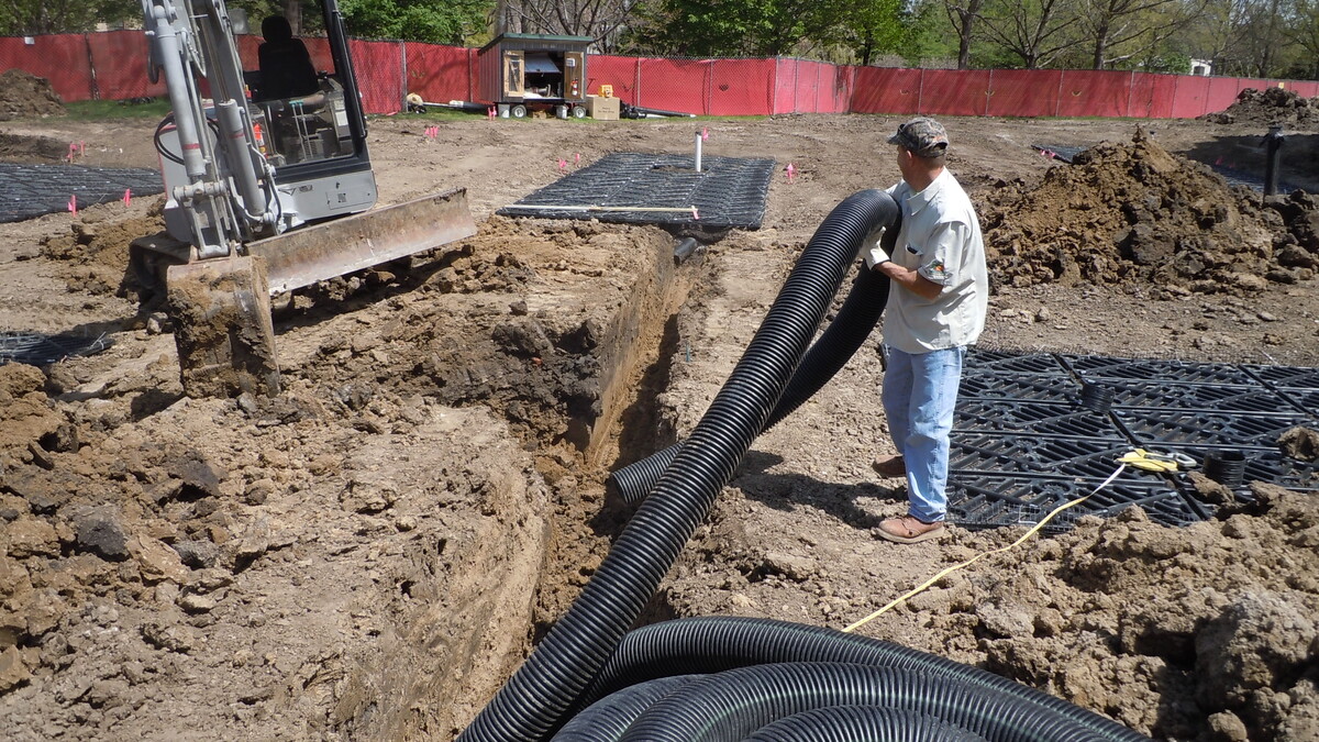 Construction workers with Dreamscapes install the overflow drainpipe that connects the silva cell structures to the storm sewer. The overflow pipe acts only as a precaution in larger rain events or a succession of rain events if the silva cells become saturated.