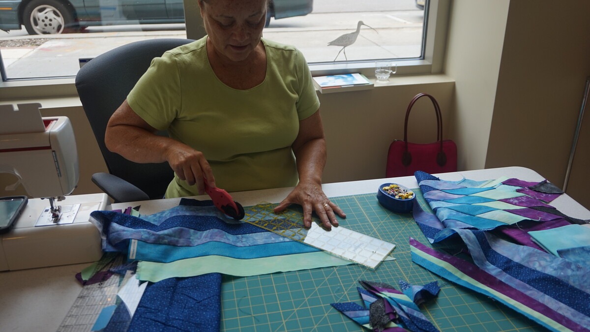 Artist Gwen Westerman cuts fabric during her first visit to the Great Plains Art Museum in early September. Westerman, the 2015 Elizabeth Rubendall Artist in Residence, will complete the artwork she started then during her next visit, Nov. 11-14.