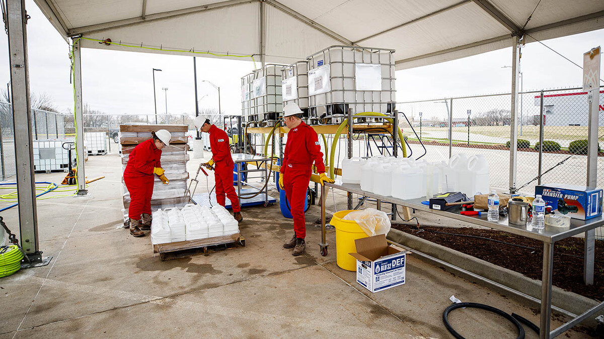 Hand sanitizer is mixed and loaded into jugs inside a fenced-off section of the Food Innovation Center parking lot. More than 6,800 gallons of the hand sanitizer has been shipped to the USDA for use by food safety inspectors.