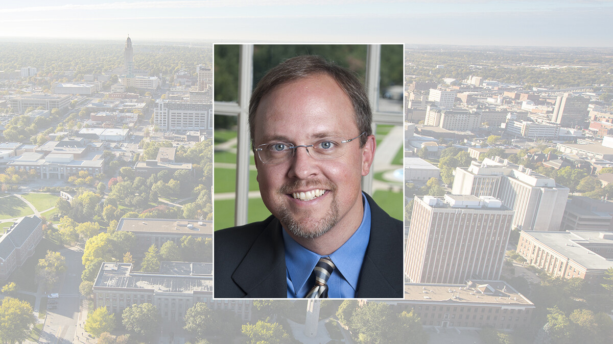 Color photo of Andrew Graybill on color campus background