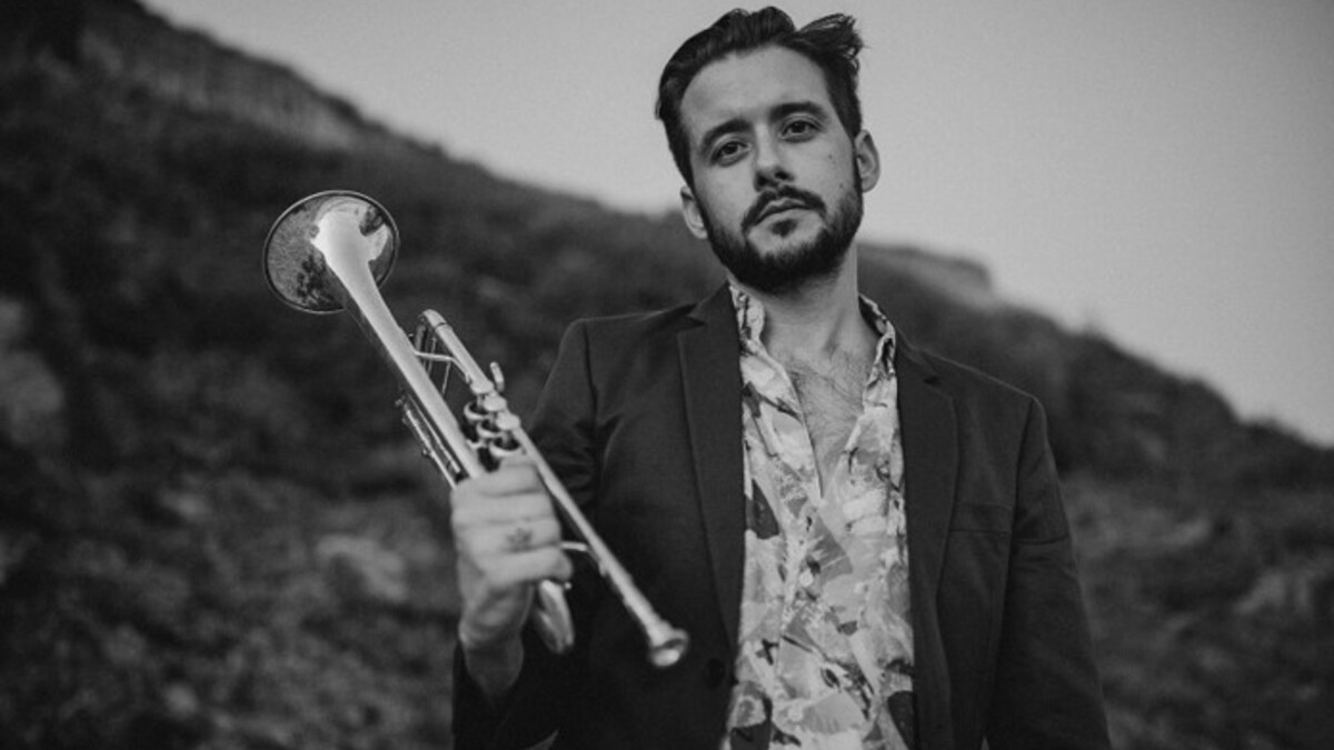 Black-and-white portrait of Jay Jennings holding a trumpet.