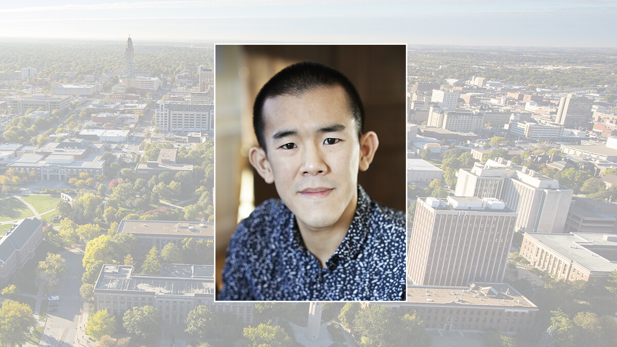 Color portrait of Ed Yong, science journalist and bestselling author, on color campus background.