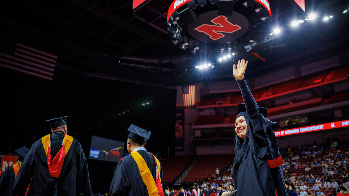 Mermen Palvanova (right) waves to family members during the graduate and professional degree ceremony May 16 at Pinnacle Bank Arena.