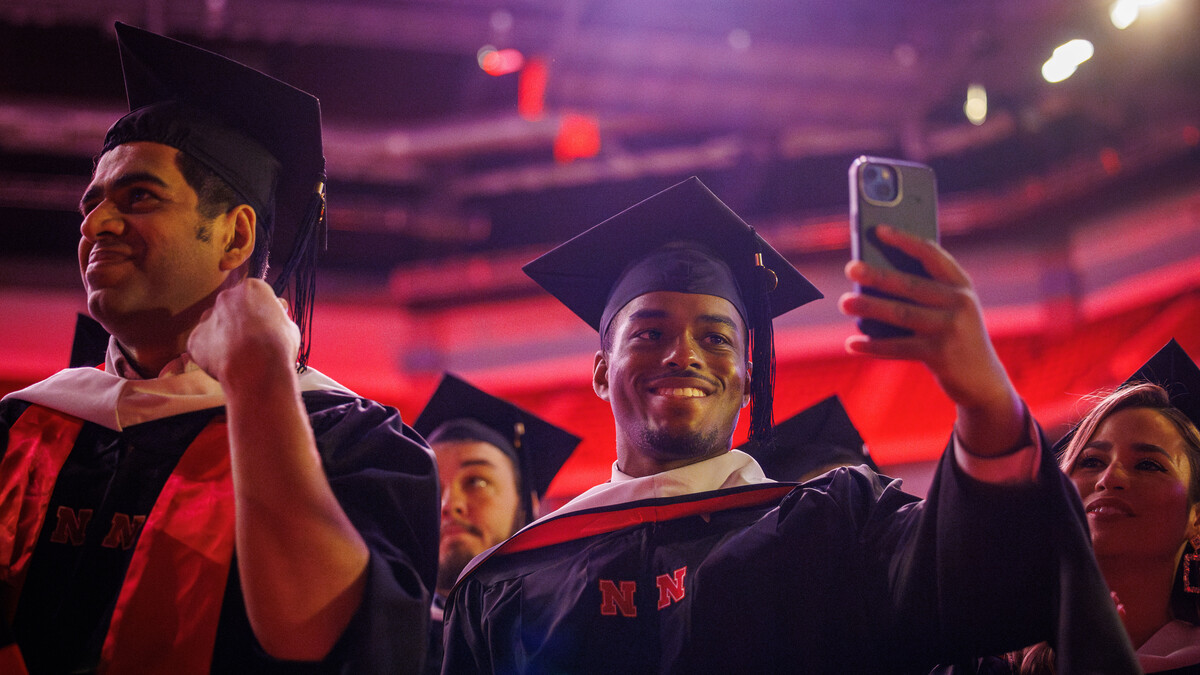 Jordan Ambrose takes a selfie after moving the tassel on his graduation cap near the end of the graduate and professional degree ceremony May 16 at Pinnacle Bank Arena.
