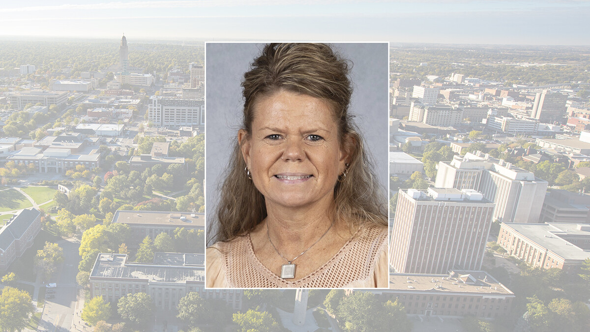 Color portrait of Terri Hogue, math teacher at Falls City Middle School, on a UNL campus background.