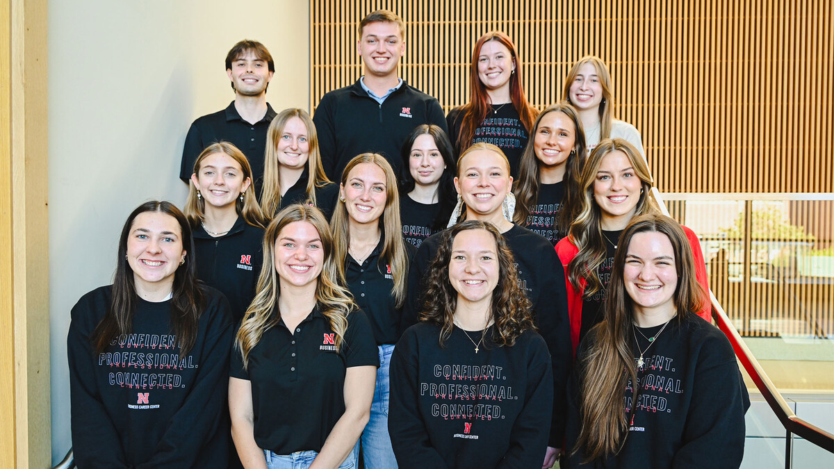 Thirteen young women and two young men — all peer career coaches in the University of Nebraska–Lincoln's College of Business, pose for a group photo on a staircase.