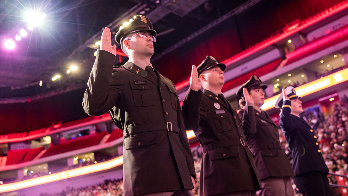 Two young men and two young women in uniform hold their right hands up to recite an oath during the undergraduate commencement ceremony Dec. 20 at Pinnacle Bank Arena.