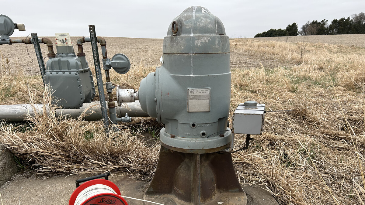 A well measuring tape is positioned next to an irrigation well head in preparation for making a water level measurement.