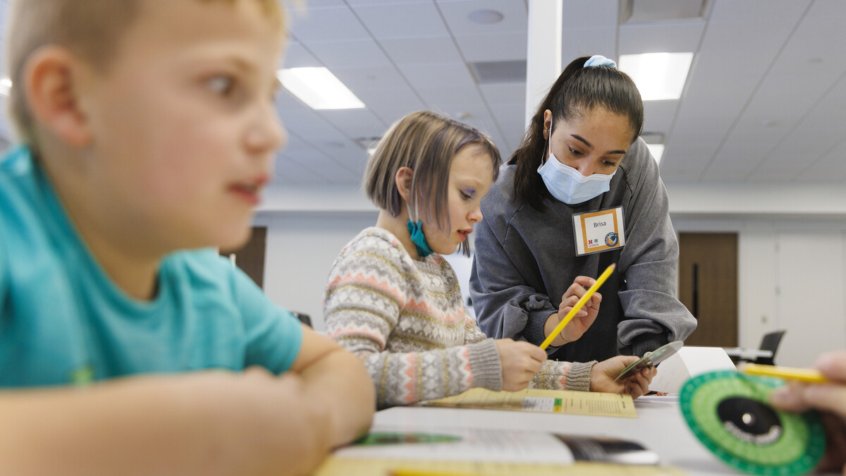 Honors student Brisa Rios helps 8-year-old Audrey with decoding using a cipher wheel