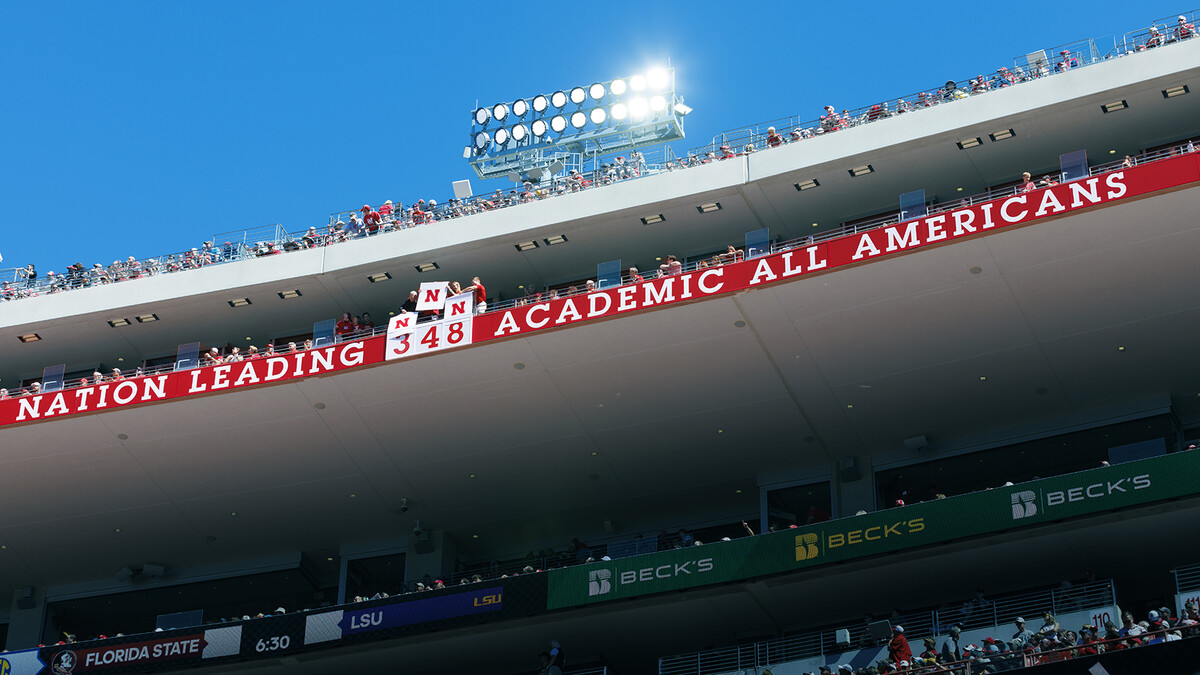 Husker fans remove plates in Memorial Stadium to show that Nebraska leads the nation with 348 Academic All-American selections.