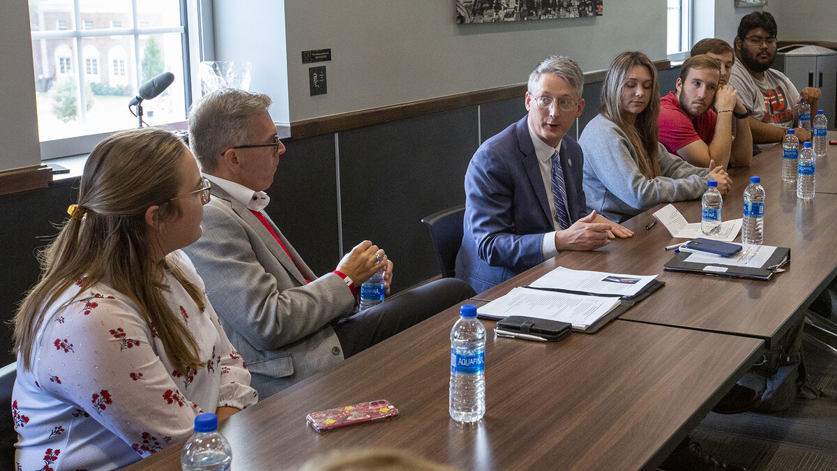 James Kvaal (center, in blue suit) talks with students and Chancellor Ronnie Green during his visit to campus on Sept. 16. Kvaal, who is from Massachusetts, often visited his grandparents in Omaha as a youth, and attended Husker football games.