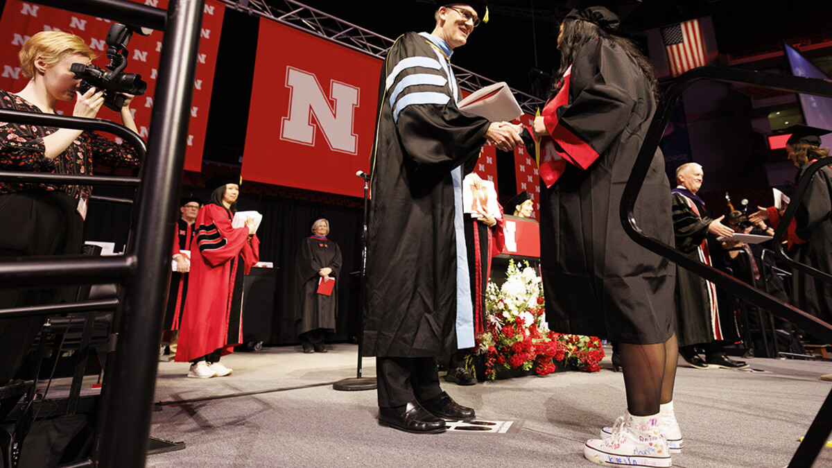 Crandall Blake receives her diploma from acting dean Nicholas J. Pace. Blake is wearing high tops she had her kindergarten students she student taught sign so they could walk on stage with her.