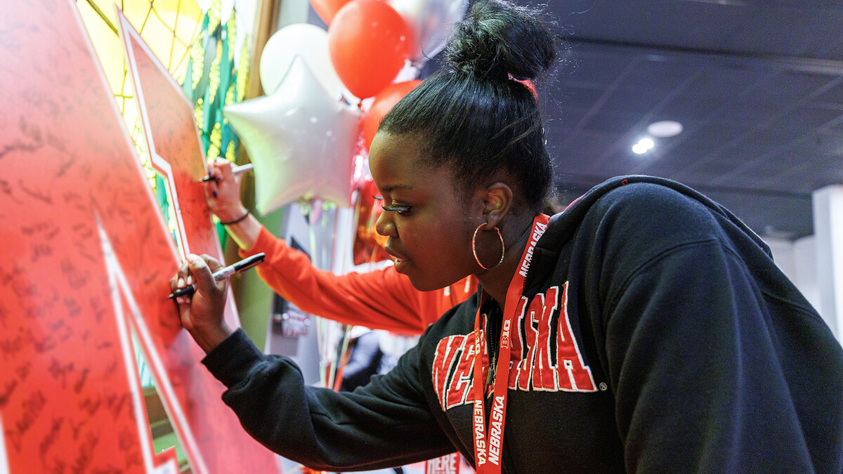 A prospective student signs her name on a "N" banner during Admitted Student Day on March 29. The event featured a chance to connect with faculty, staff and fellow students as participants learned what it means to be a Husker.
