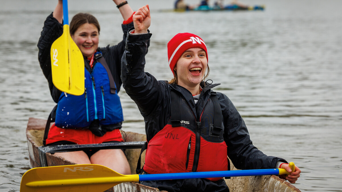 Lauren Flickinger and Chloe Mann, both senior Civil Engineering majors, cheer as they return to the shore after competing in the female sprint of the ASCE Concrete Canoe Competition at Holmes Lake. 