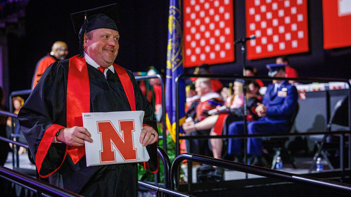 Corrie Svehla, the Assistant Director of Special Events for UNL walks down the stage after receiving his diploma.