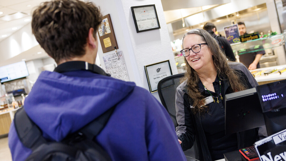 Claudia Wheeler (right), a Dining Services clerical associate, smiles as she scans student Ncards at the Nebraska East Union Dining Hall.