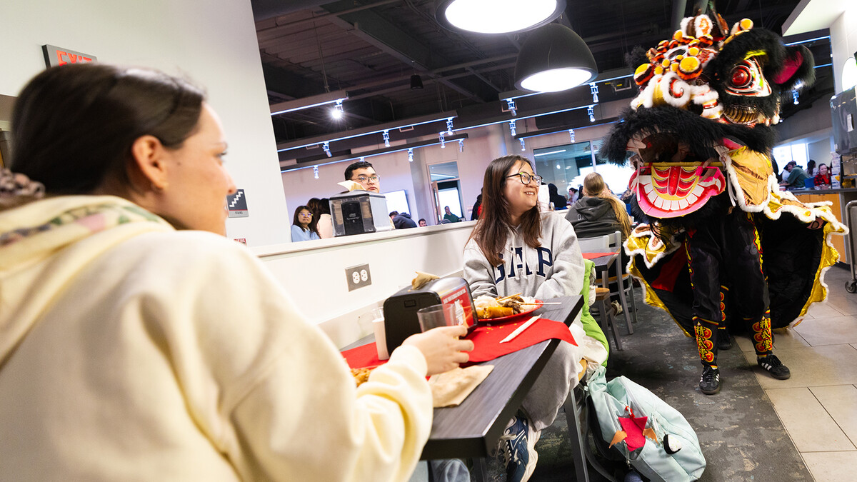 Students reaction with surprise as Lion Dancers pass by in Cather Dining Center.