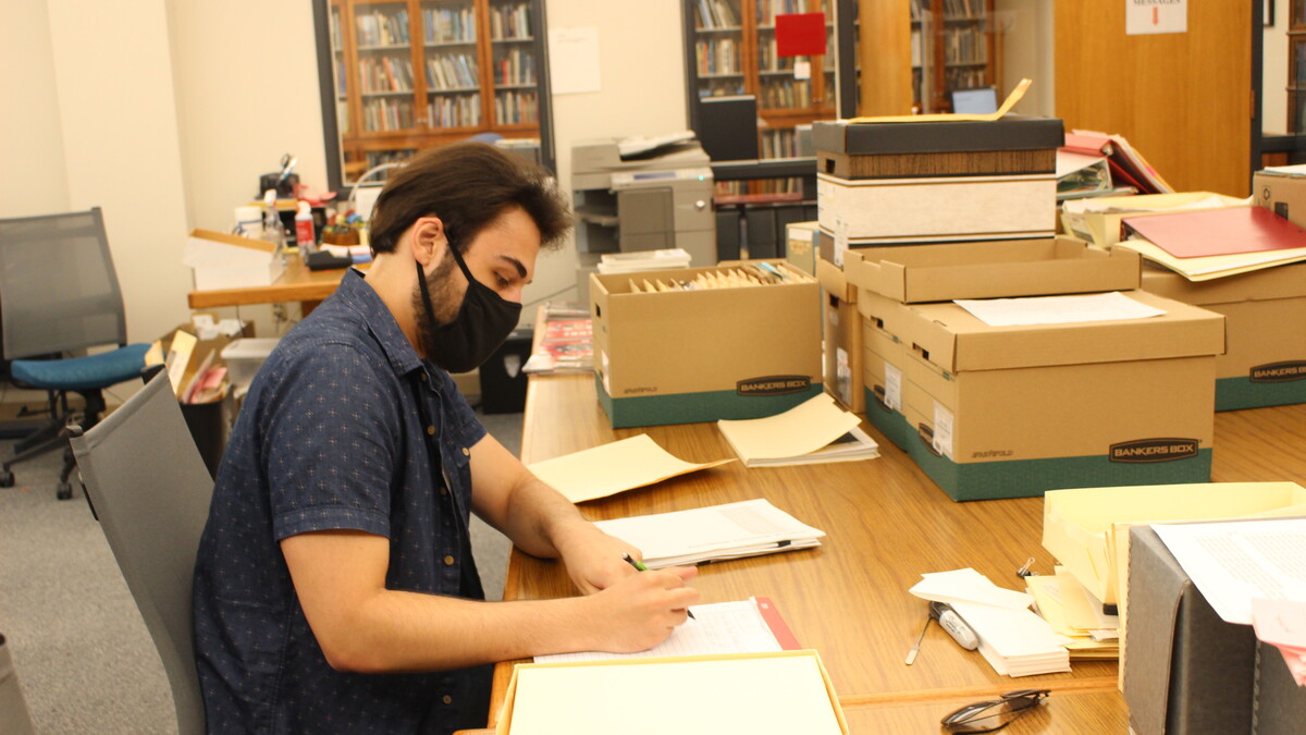 Jake Borgmann, senior, works in the Archives & Special Collections processing the Mark Awakuni-Swetland Papers.