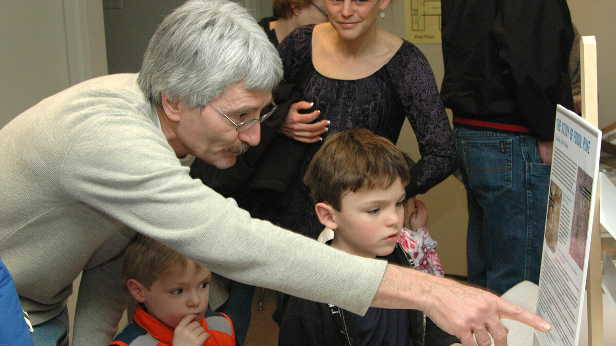 Rob Skolnick, a preparator with the University of Nebraska State Museum, explains the history of fossil puke to two children during the 2011 Dinosaurs and Disasters event in Morrill Hall.