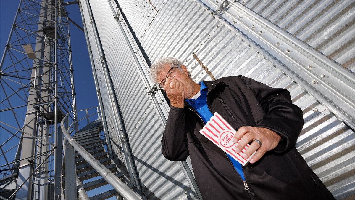 Norm Krug eating popcorn next to grain bin