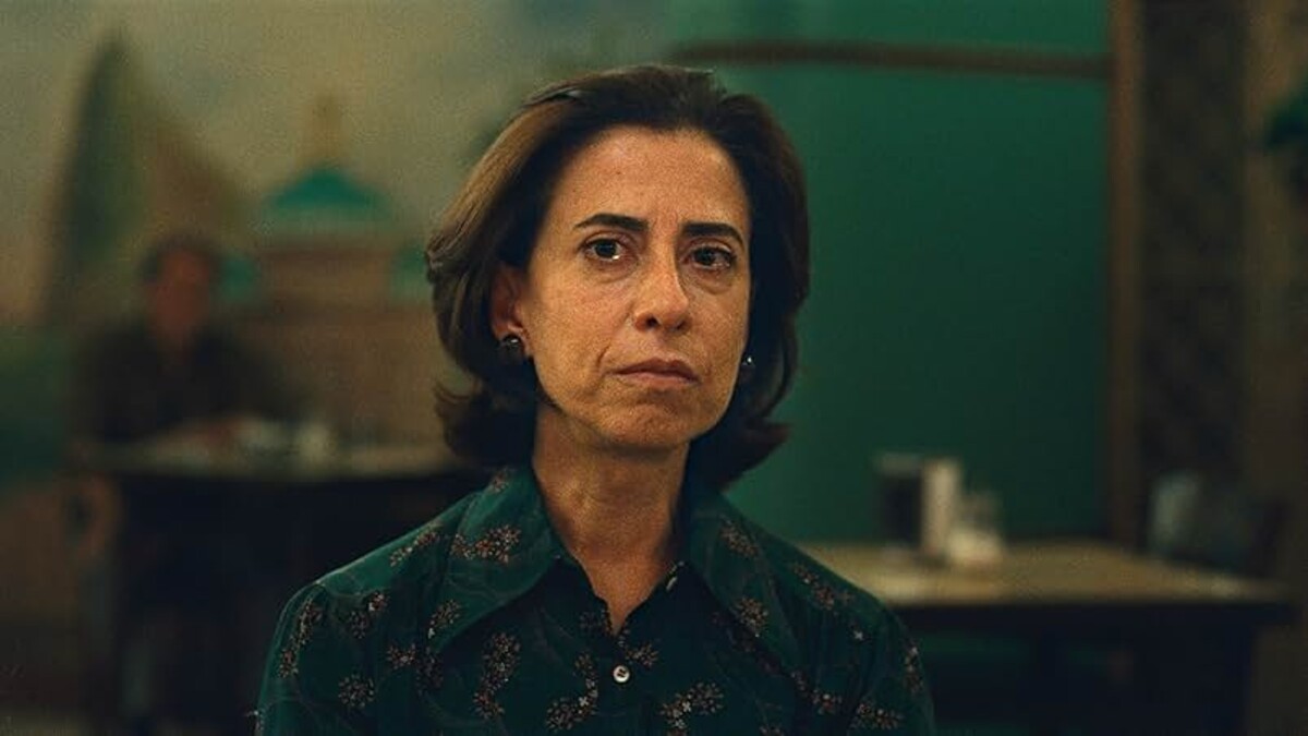 A tearful brunette woman in a blue blouse sits in the center of the image.