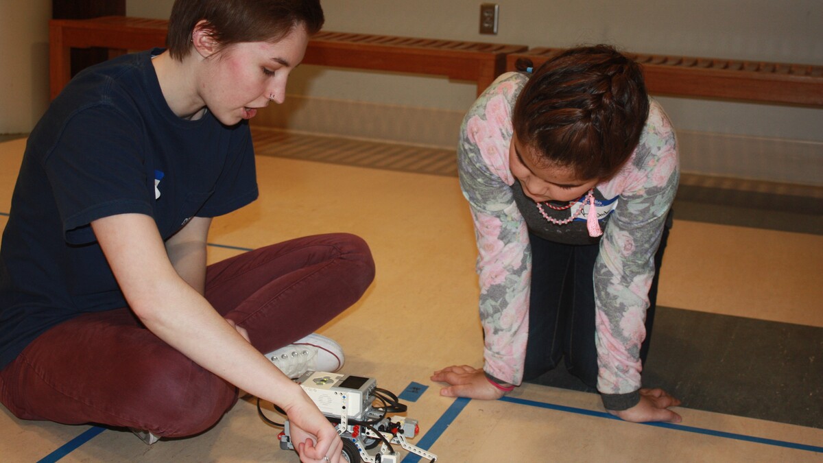 Computing for All member Allison Buckley helps a Girl Scout program a robot at last month's Girl Scout camp.