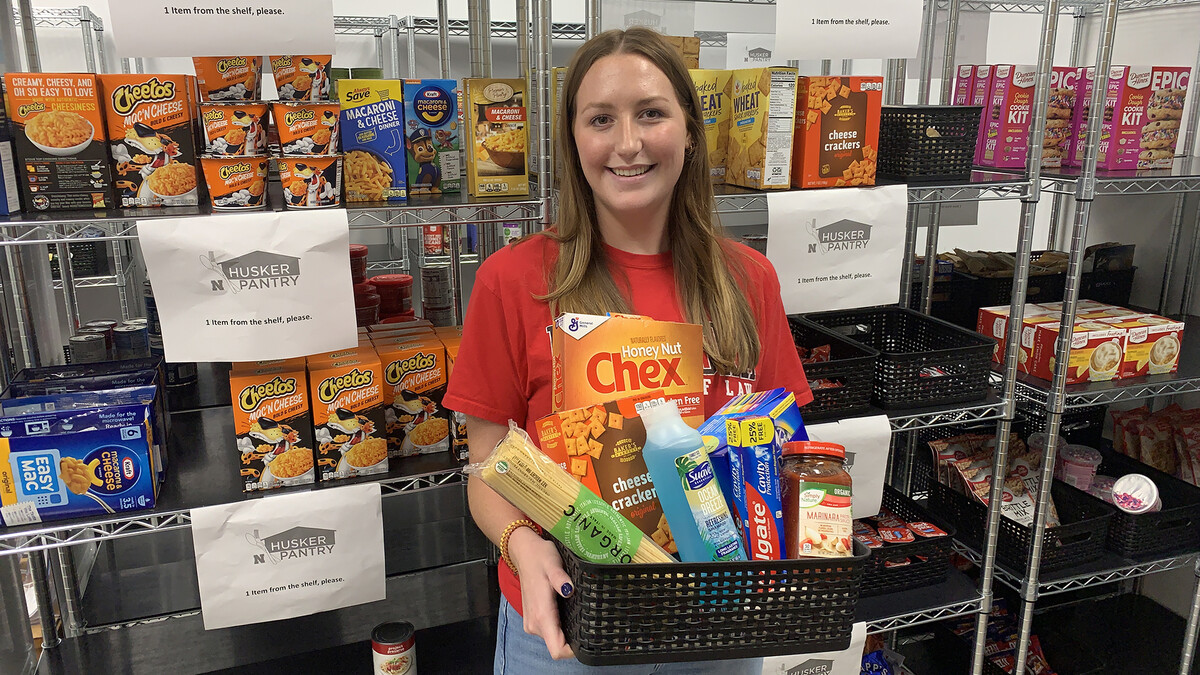 Husker Pantry graduate assistant Emilee Smith displays a basket of personal care and food items that are commonly-requested by University of Nebraska–Lincoln students. [Christopher Dulak | Student Affairs]