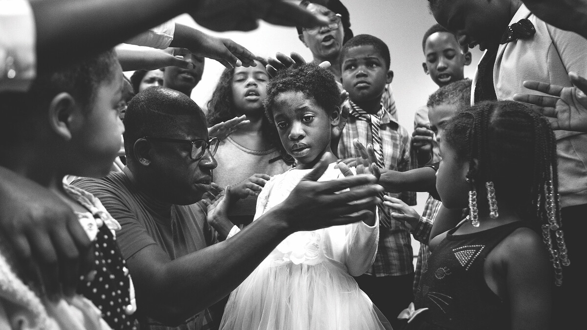 Members of the New Life Tabernacle congregation pray over Josnika Adult, 5, on Oct. 22, 2017, in Belle Glade, Florida.
