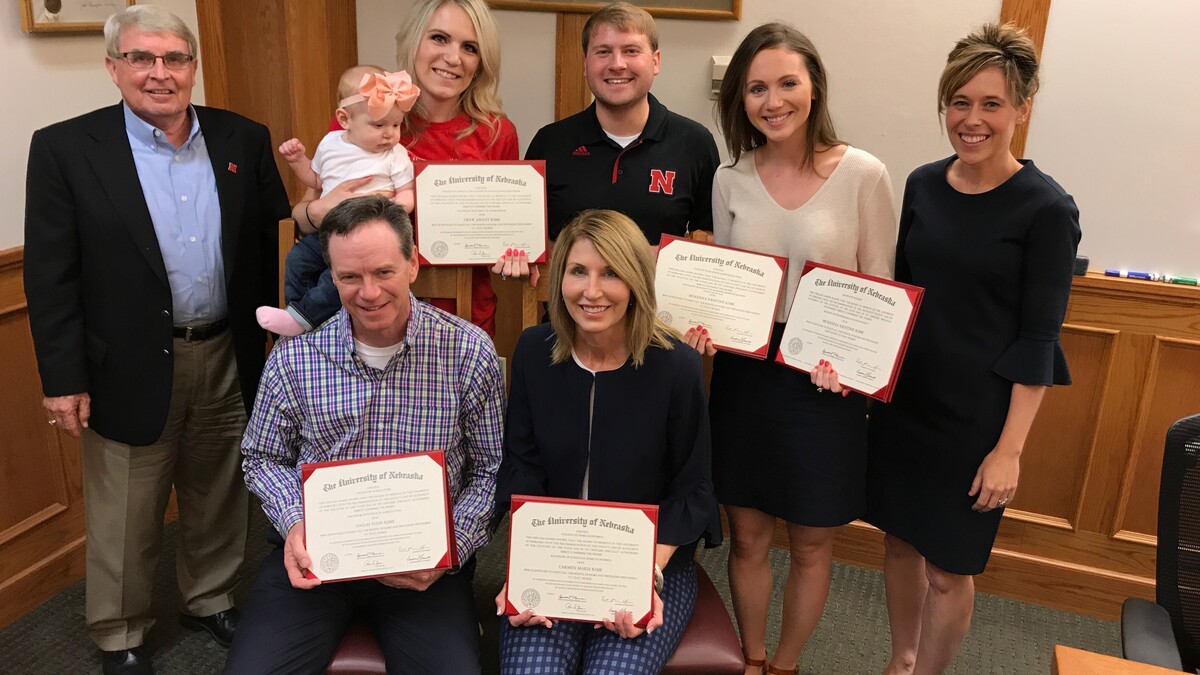 Nebraska’s Steve Waller and Tiffany Heng-Moss presented replacement degrees to the Kime family after a fire destroyed their home and belongings. The presentation included (seated, from left) Dallas and Carmen Kime; (standing, from left) Waller, Drew Kime, Eric Kamler, McKenna Kime and Heng-Moss.