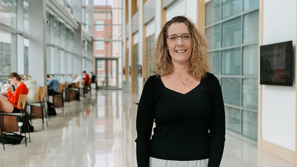 Assistant Director of Professional & Life Skills for the Business Career Center Mikki Sandin stands in the College of Business's Hawks Hall. 