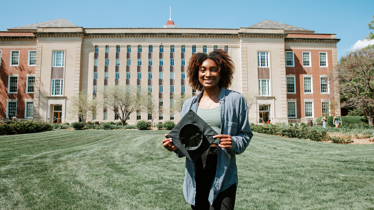 Standing in front of Love Library, Wright shows off a Grad Cap Remix insert.  