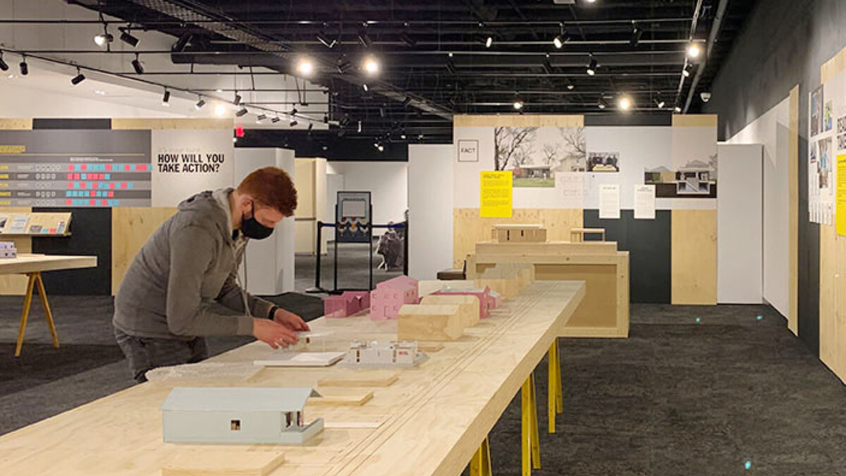 A student helps set up the NEw Attainable House exhibit