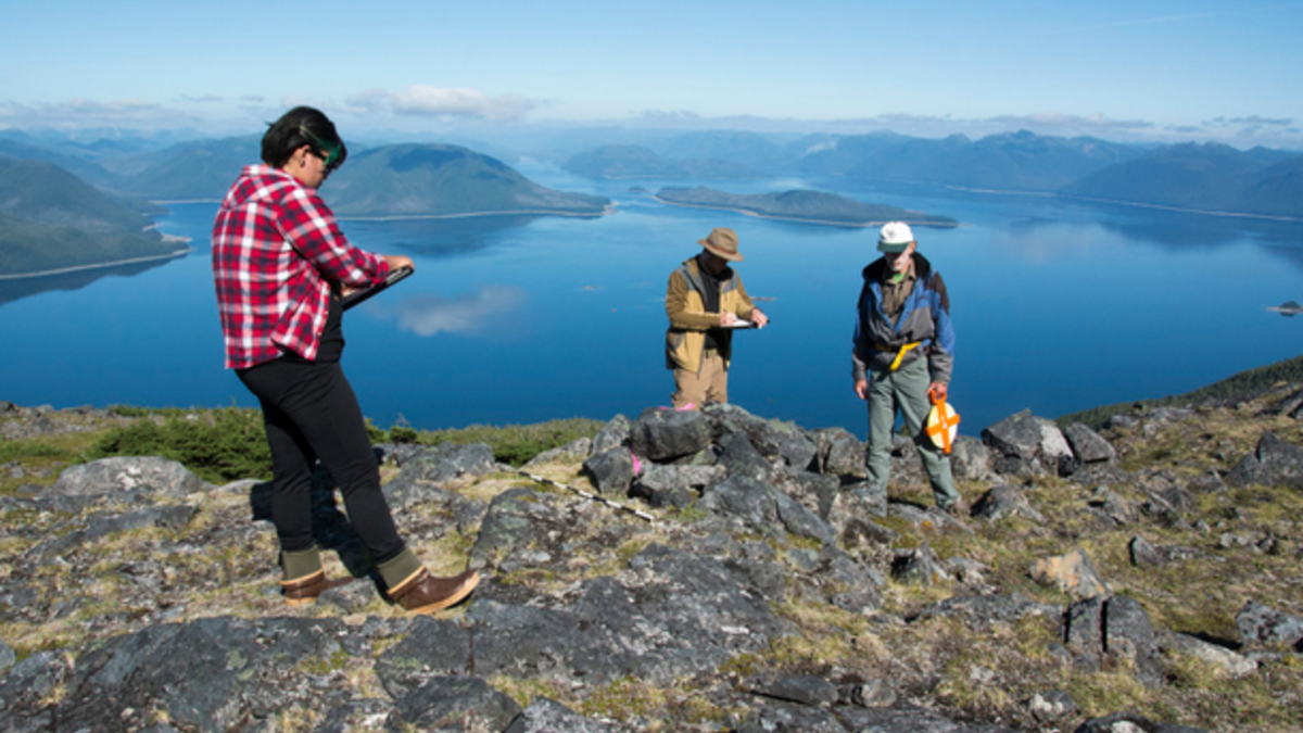 Researchers (from left) Elizabeth Howard, Mike Chondoronek and Ralph Hartley record initial observations of an Alaskan alpine cairn.